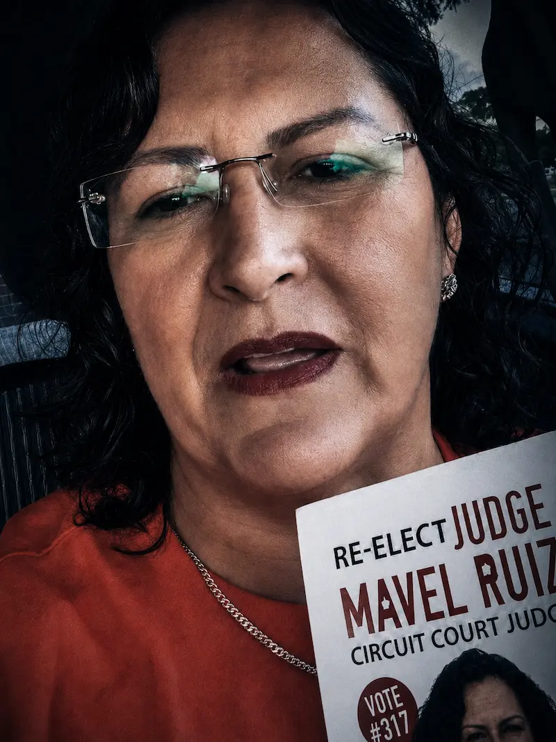 Judge Mavel Ruiz holding a re-election campaign flyer.